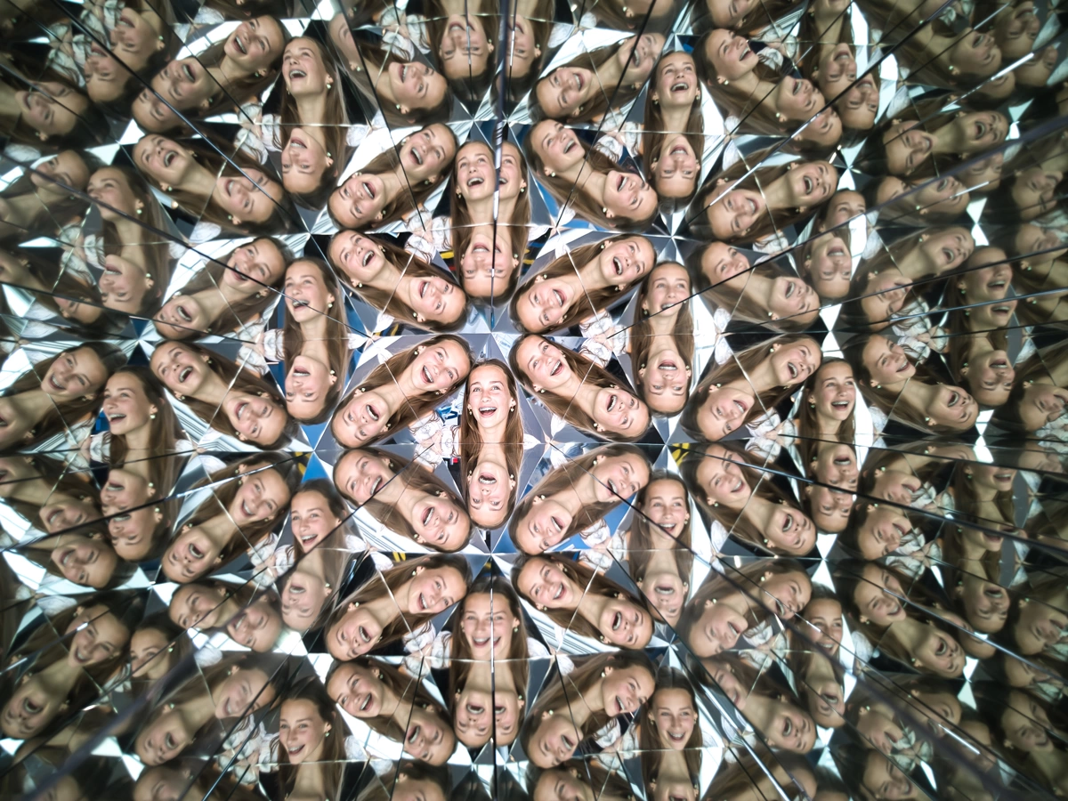 A woman's face is reflected in a kaleidoscopic pattern at Museum of Illusions Atlanta.