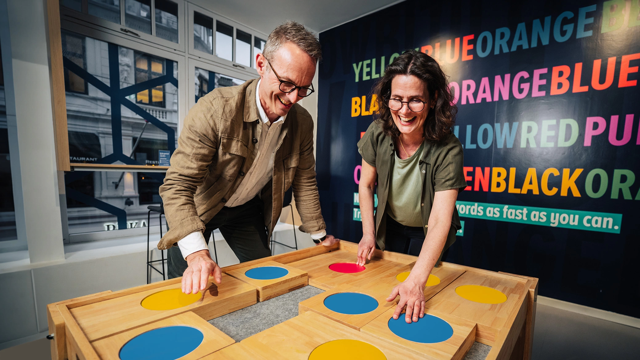 A man and a woman are having fun while solving a giant puzzle at Museum of Illusions Atlanta.